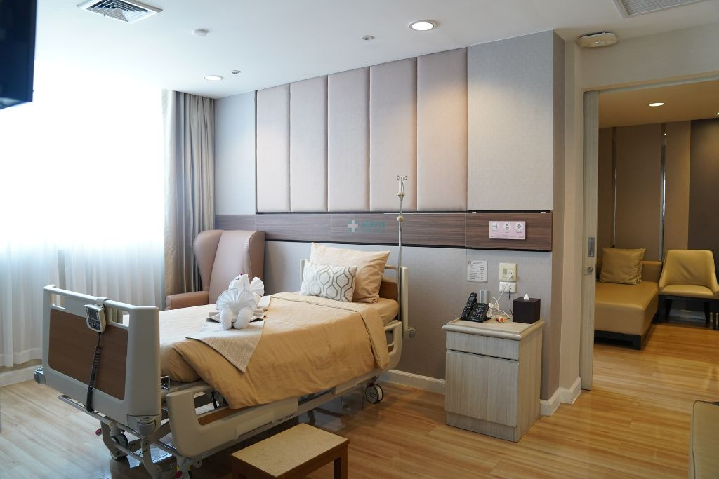 ภาพประกอบห้องพักโรงพยาบาลพร้อมเตียงและพื้นที่สำหรับญาติ